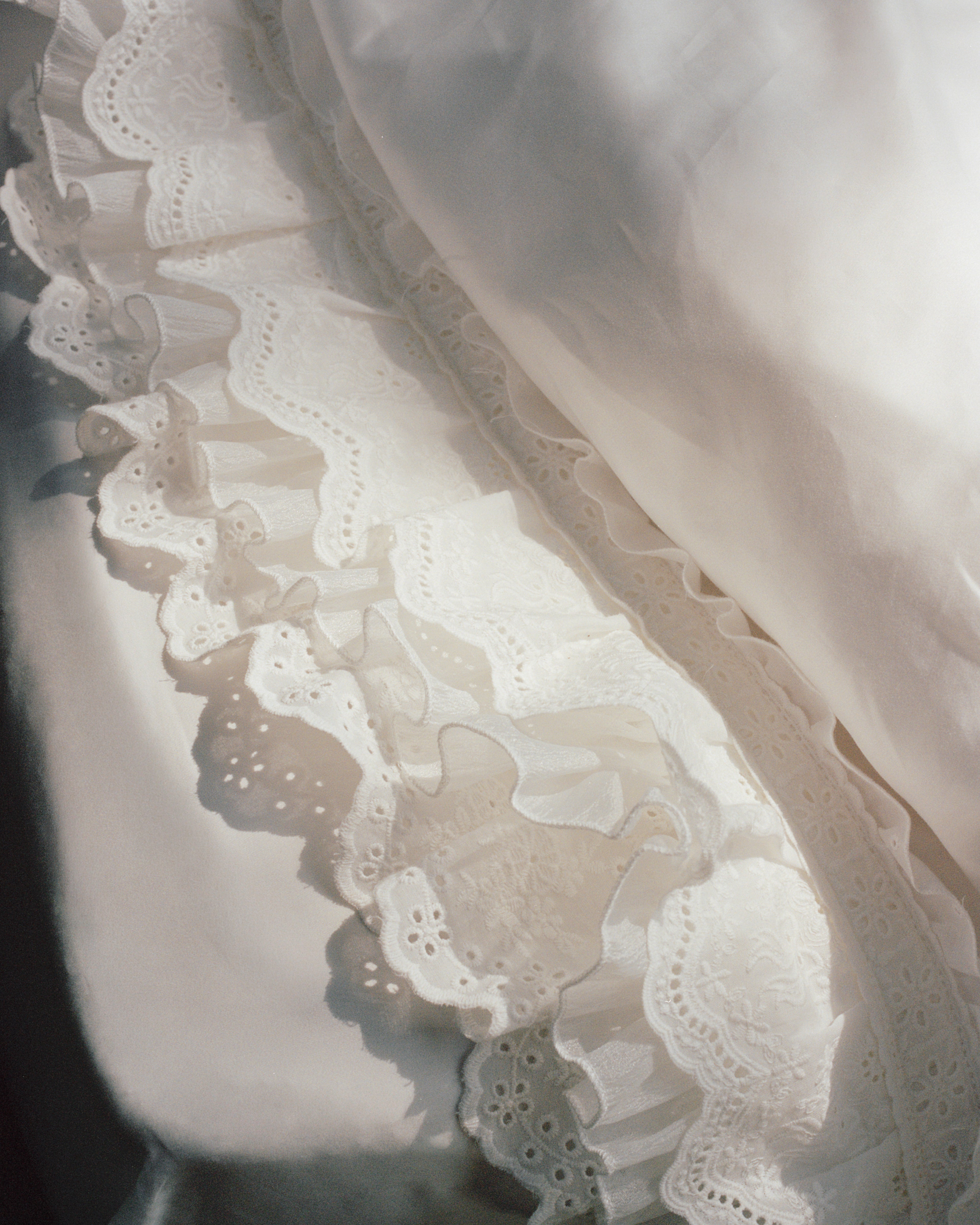Close-up of layered scalloped ruffles and airy gauze detailing on the Crème duvet cover
