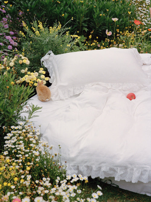 Chantilly romantic bedding set styled outdoors with ruffled pillowcases and duvet cover