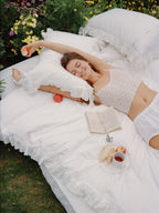 Woman relaxing on the Chantilly ruffle and bow bedding set outdoors