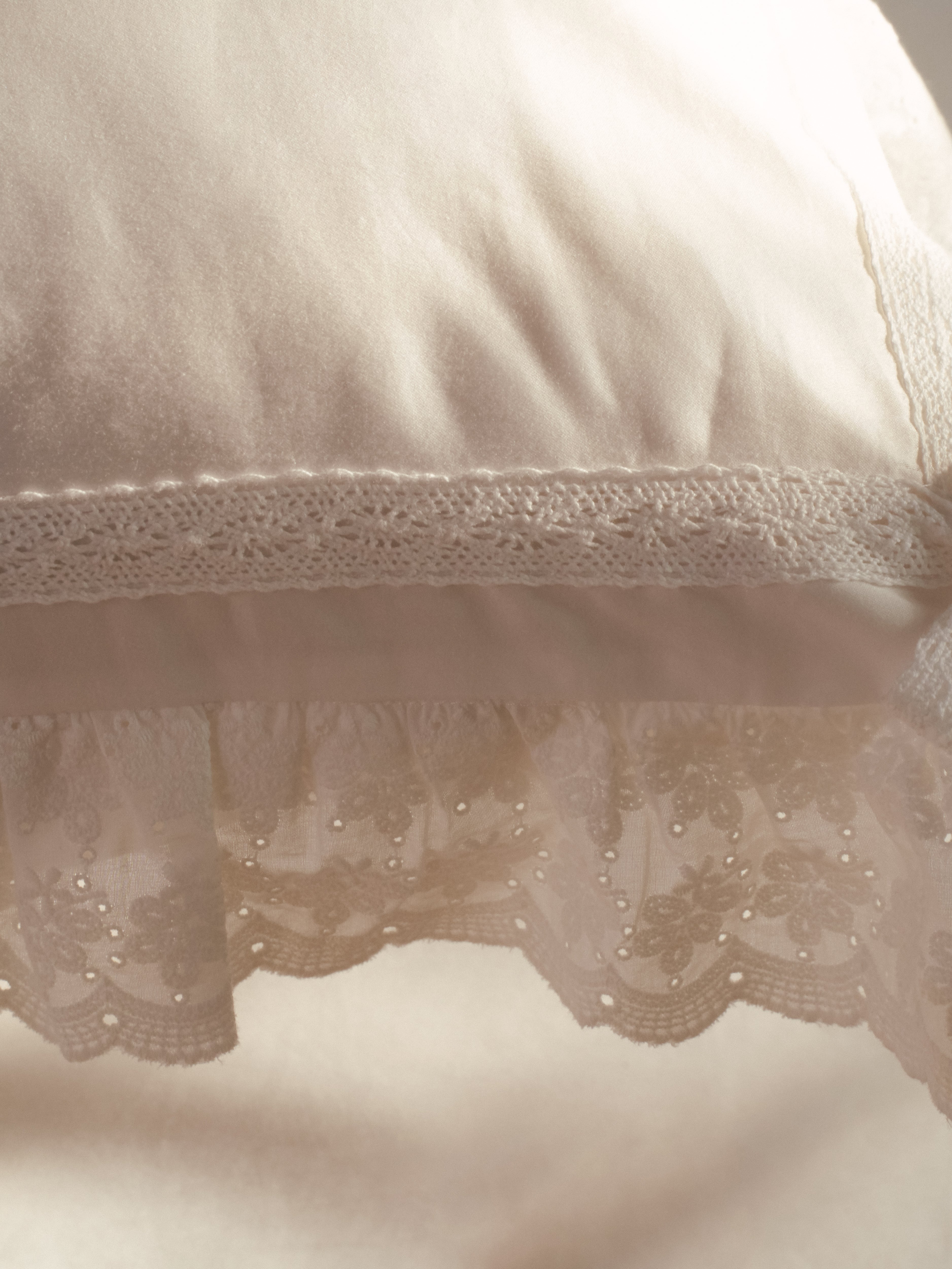 Close-up of scalloped eyelet ruffle and cotton lace trim on the Chantilly pillowcase
