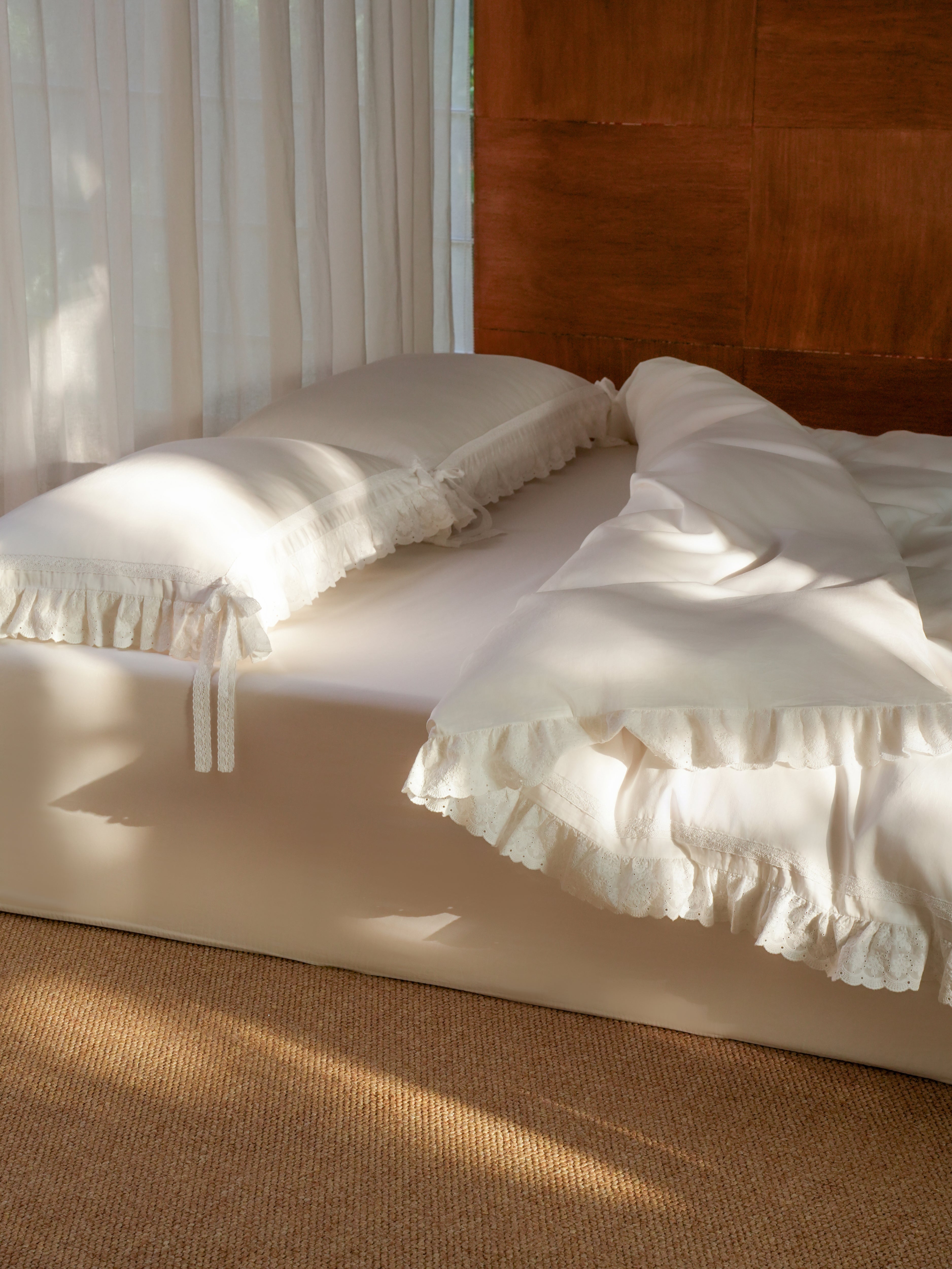 Chantilly bedding set with ruffle duvet cover and ruffle and bow-detail pillowcases on a sunlit bed