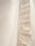 Close-up of scalloped eyelet ruffle and cotton lace trim from the Chantilly Collection