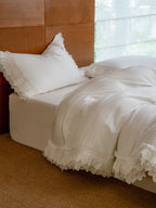 Crème layered ruffle duvet cover in ivory Egyptian cotton sateen on a styled bed