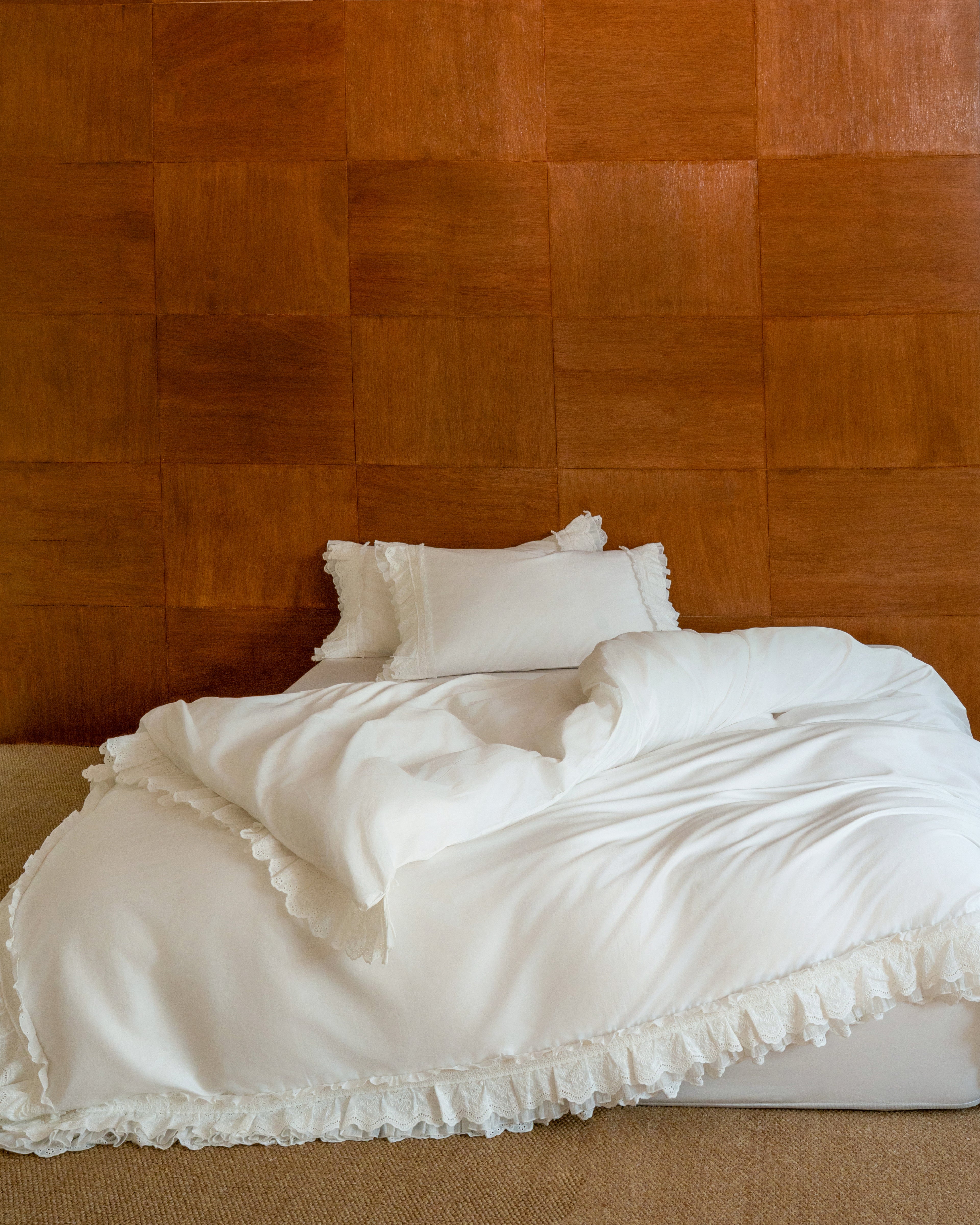 Crème ruffle duvet cover styled on a bed with layered scalloped edging