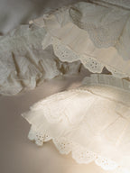 Close-up of layered scalloped ruffles and airy gauze detailing on the Crème pillowcase