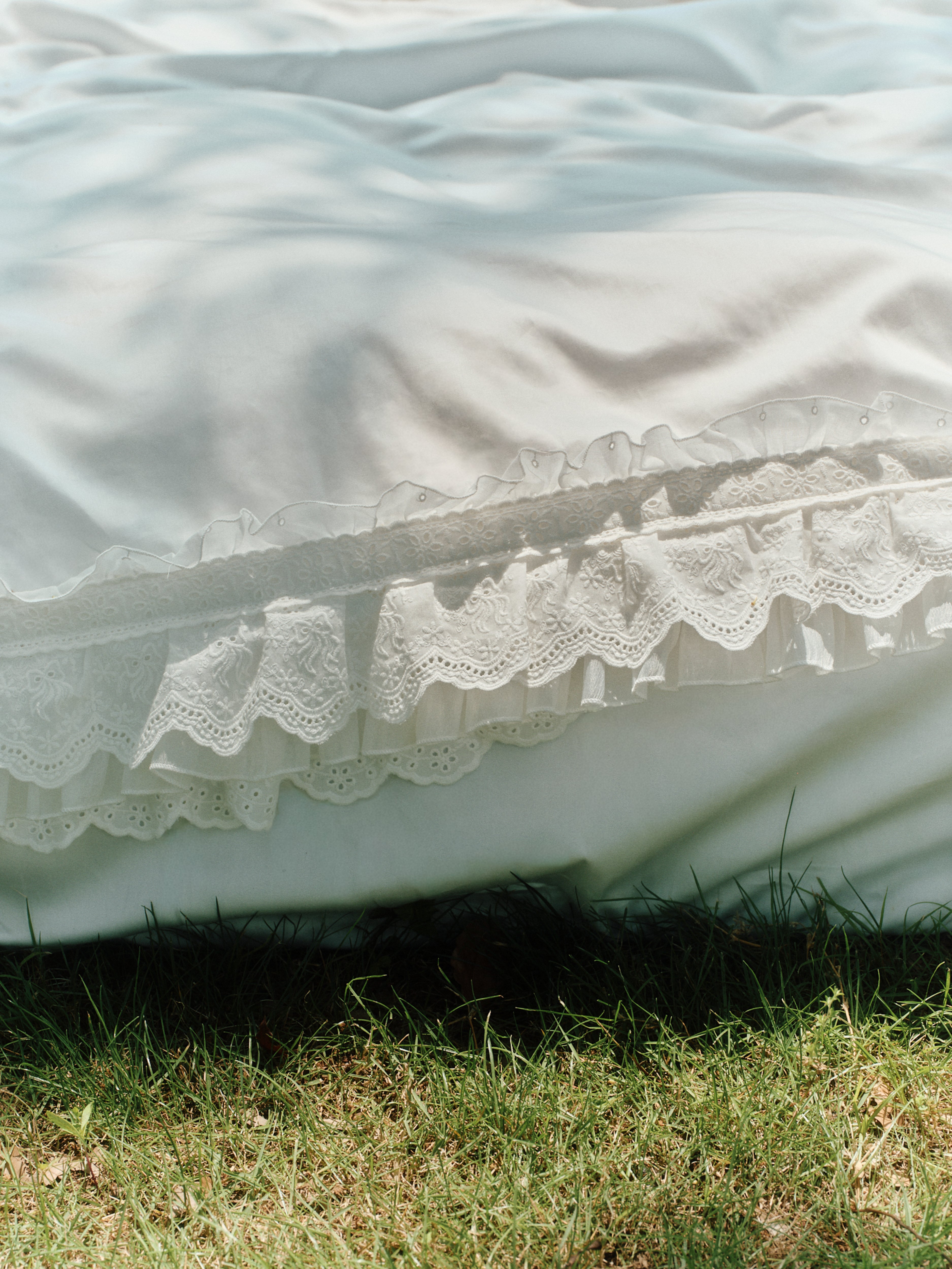 Close-up of layered ruffles on the Crème Egyptian cotton bedding set outdoors