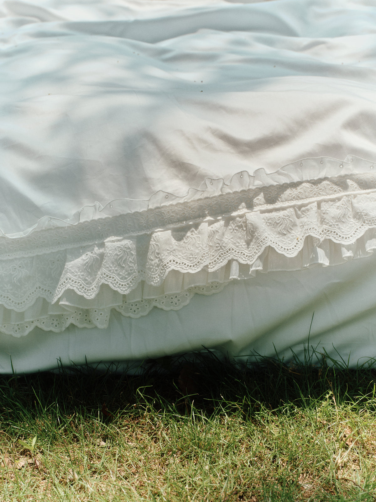 Close-up of layered ruffles on the Crème Egyptian cotton bedding set outdoors