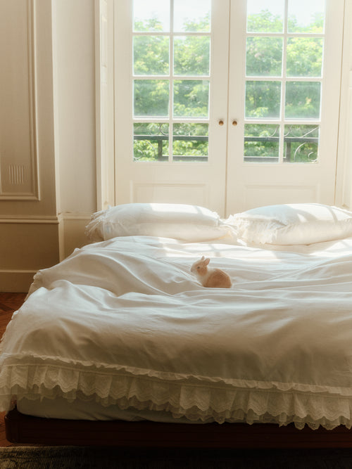 Crème layered ruffle bedding set styled in a bright bedroom