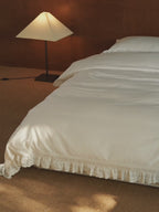 Chantilly ruffle duvet cover draped over a bed with scalloped edging