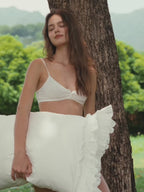 Woman holding a Crème layered ruffle pillowcase outdoors