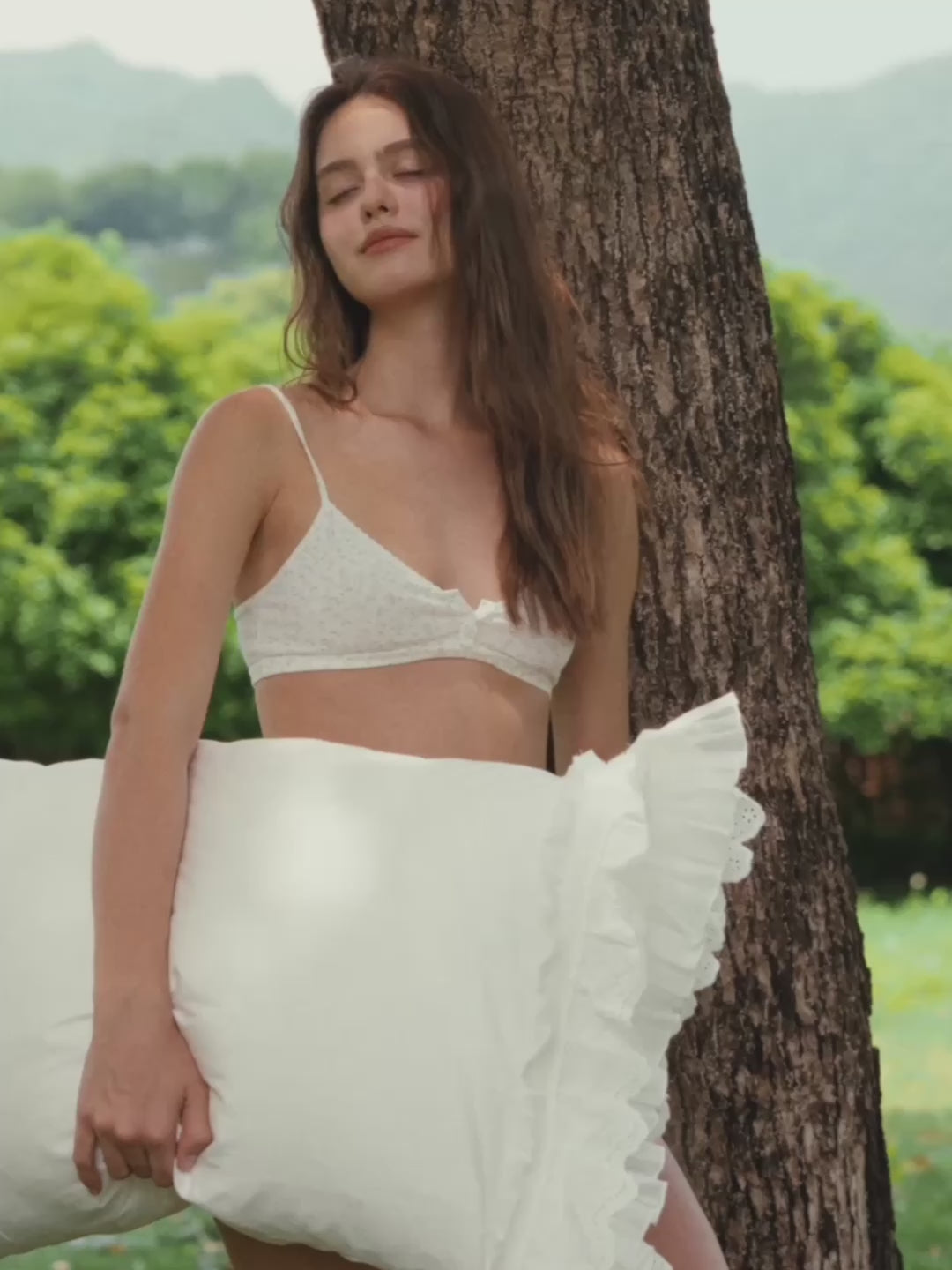 Woman holding a Crème layered ruffle pillowcase outdoors